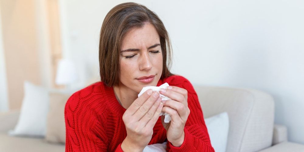 Donna sofferente per via dell'allergia, che non ha ancora trovato il modo di ridurre gli allergeni.