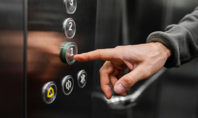 Uomo che prenota il suo piano in un dopo le pulizie ascensori
