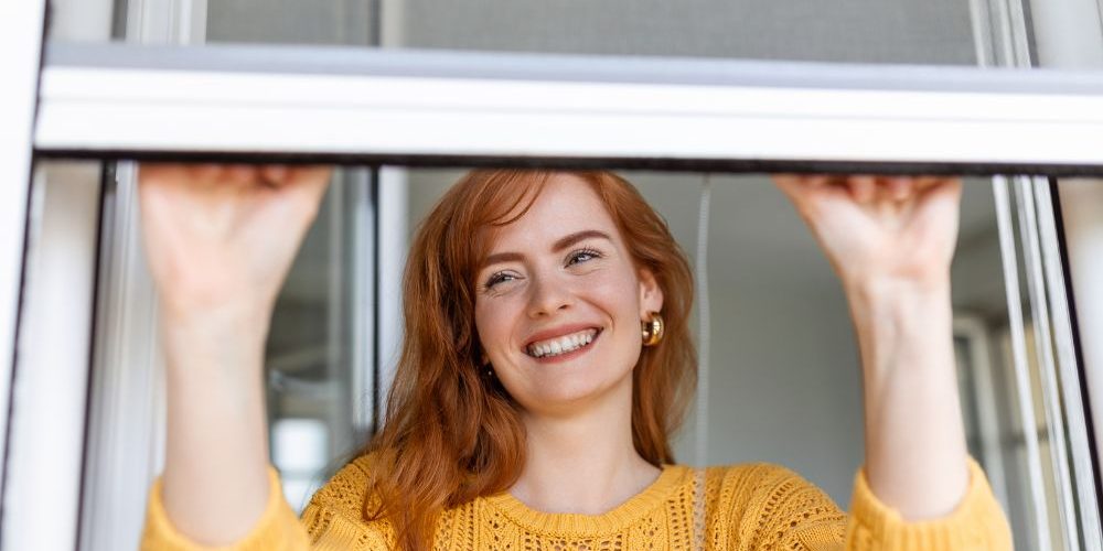 woman-hand-hold-retractable-pleated-insect-screen-holder-open-close-window-mosquito-nets Ragazza che apre la zanzariera pulita