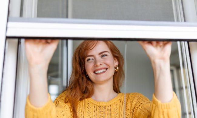 woman-hand-hold-retractable-pleated-insect-screen-holder-open-close-window-mosquito-nets Ragazza che apre la zanzariera pulita